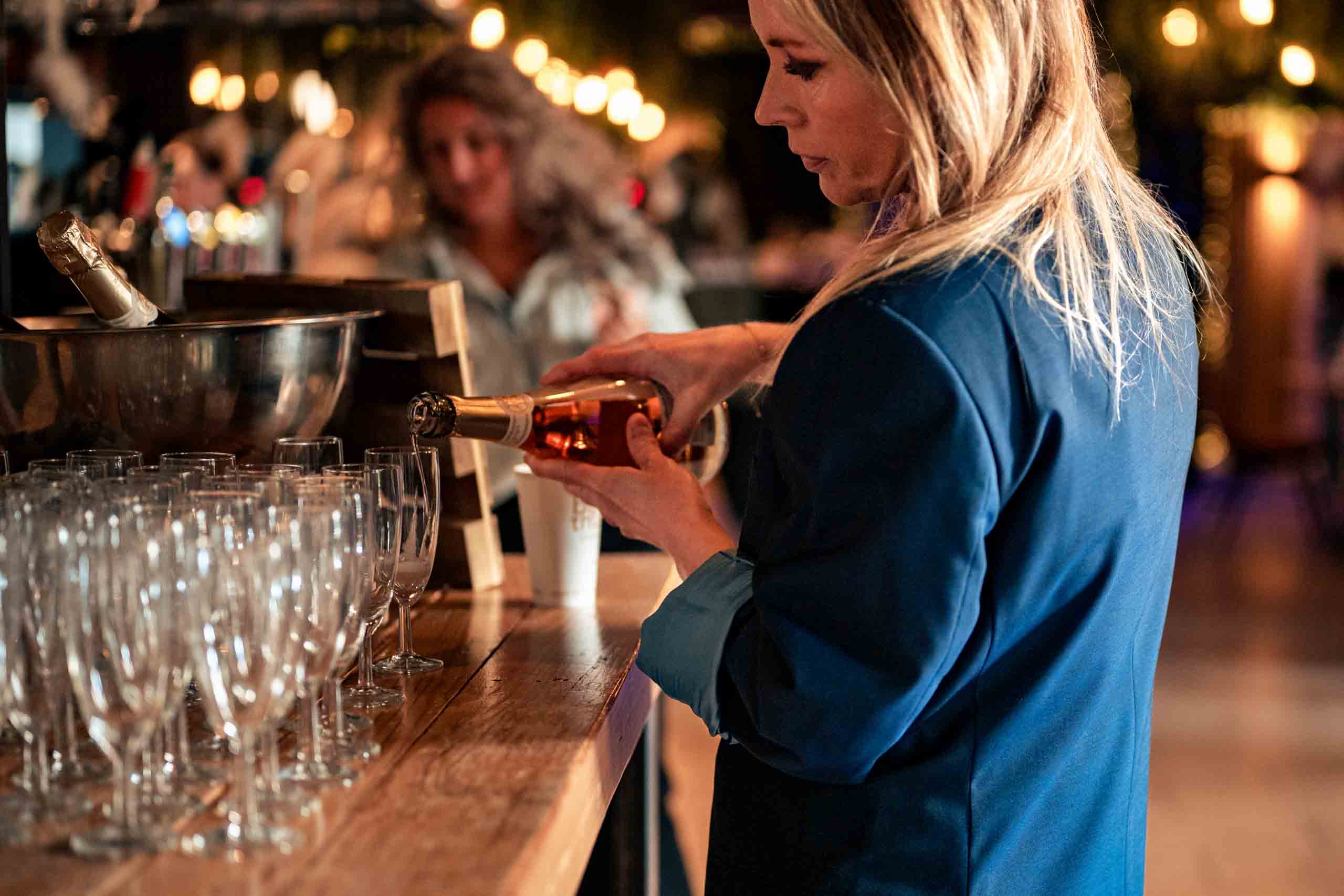gastvrouw schenkt welkomstdrankje in